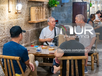 Residents are drinking tea at an old teahouse in a bomb shelter as the high temperature continues in Chongqing, China, on July 21, 2024. (