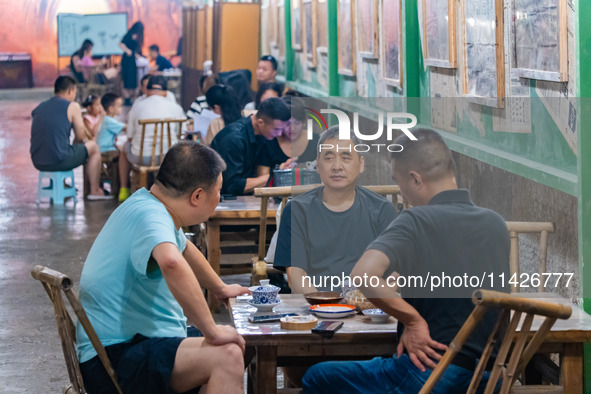 Residents are drinking tea at an old teahouse in a bomb shelter as the high temperature continues in Chongqing, China, on July 21, 2024. 