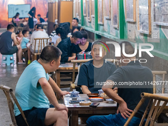 Residents are drinking tea at an old teahouse in a bomb shelter as the high temperature continues in Chongqing, China, on July 21, 2024. (