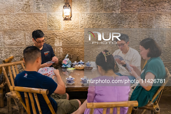 Residents are drinking tea at an old teahouse in a bomb shelter as the high temperature continues in Chongqing, China, on July 21, 2024. 