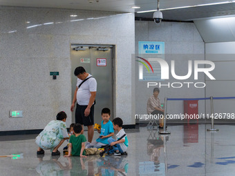 Citizens are cooling off at a rail transit platform as the high temperature continues in Chongqing, China, on July 21, 2024. (