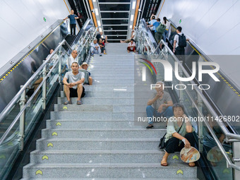 Citizens are cooling off at a rail transit platform as the high temperature continues in Chongqing, China, on July 21, 2024. (