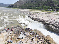 Tourists are visiting Hukou Waterfall on the Yellow River at the junction of Yichuan county and Ji county in North China's Shaanxi province,...