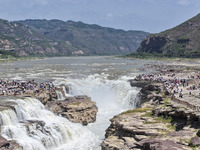 Tourists are visiting Hukou Waterfall on the Yellow River at the junction of Yichuan county and Ji county in North China's Shaanxi province,...