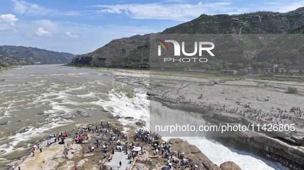 Tourists are visiting Hukou Waterfall on the Yellow River at the junction of Yichuan county and Ji county in North China's Shaanxi province,...