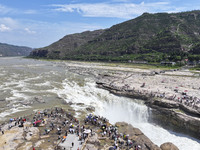 Tourists are visiting Hukou Waterfall on the Yellow River at the junction of Yichuan county and Ji county in North China's Shaanxi province,...