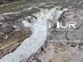 Tourists are visiting Hukou Waterfall on the Yellow River at the junction of Yichuan county and Ji county in North China's Shaanxi province,...