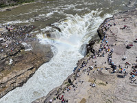 Tourists are visiting Hukou Waterfall on the Yellow River at the junction of Yichuan county and Ji county in North China's Shaanxi province,...