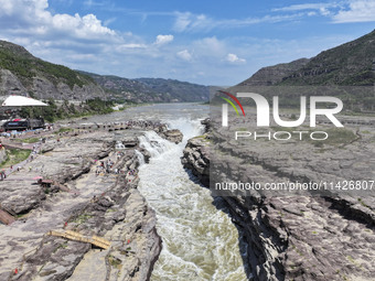 Tourists are visiting Hukou Waterfall on the Yellow River at the junction of Yichuan county and Ji county in North China's Shaanxi province,...