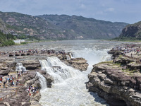 Tourists are visiting Hukou Waterfall on the Yellow River at the junction of Yichuan county and Ji county in North China's Shaanxi province,...