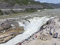 Tourists are visiting Hukou Waterfall on the Yellow River at the junction of Yichuan county and Ji county in North China's Shaanxi province,...