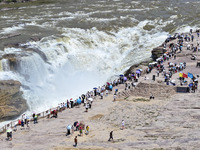 Tourists are visiting Hukou Waterfall on the Yellow River at the junction of Yichuan county and Ji county in North China's Shaanxi province,...