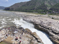 Tourists are visiting Hukou Waterfall on the Yellow River at the junction of Yichuan county and Ji county in North China's Shaanxi province,...