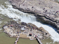 Tourists are visiting Hukou Waterfall on the Yellow River at the junction of Yichuan county and Ji county in North China's Shaanxi province,...