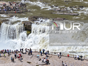 Tourists are visiting Hukou Waterfall on the Yellow River at the junction of Yichuan county and Ji county in North China's Shaanxi province,...