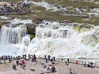 Tourists are visiting Hukou Waterfall on the Yellow River at the junction of Yichuan county and Ji county in North China's Shaanxi province,...