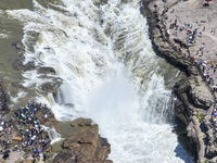 Tourists are visiting Hukou Waterfall on the Yellow River at the junction of Yichuan county and Ji county in North China's Shaanxi province,...