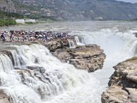 Tourists are visiting Hukou Waterfall on the Yellow River at the junction of Yichuan county and Ji county in North China's Shaanxi province,...