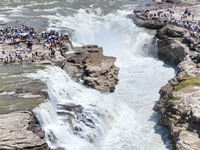 Tourists are visiting Hukou Waterfall on the Yellow River at the junction of Yichuan county and Ji county in North China's Shaanxi province,...