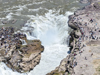 Tourists are visiting Hukou Waterfall on the Yellow River at the junction of Yichuan county and Ji county in North China's Shaanxi province,...