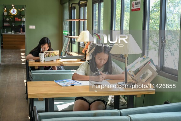 Students are reading in a green lacquered ''train book house'' in Yuping county, Guizhou province, China, on July 21, 2024. 