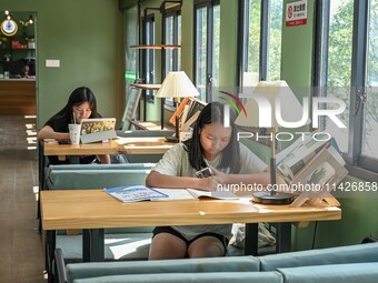 Students are reading in a green lacquered ''train book house'' in Yuping county, Guizhou province, China, on July 21, 2024. (