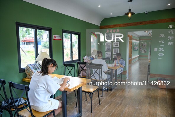 Students are reading in a green lacquered ''train book house'' in Yuping county, Guizhou province, China, on July 21, 2024. 