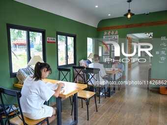 Students are reading in a green lacquered ''train book house'' in Yuping county, Guizhou province, China, on July 21, 2024. (