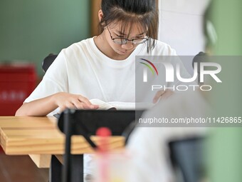 Students are reading in a green lacquered ''train book house'' in Yuping county, Guizhou province, China, on July 21, 2024. (