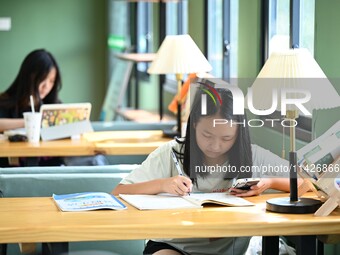 Students are reading in a green lacquered ''train book house'' in Yuping county, Guizhou province, China, on July 21, 2024. (