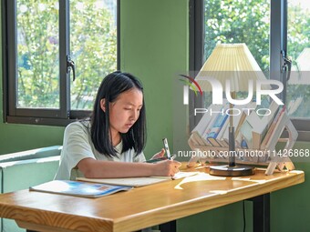 Students are reading in a green lacquered ''train book house'' in Yuping county, Guizhou province, China, on July 21, 2024. (