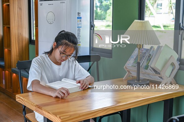 Students are reading in a green lacquered ''train book house'' in Yuping county, Guizhou province, China, on July 21, 2024. 