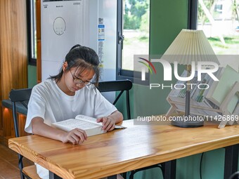 Students are reading in a green lacquered ''train book house'' in Yuping county, Guizhou province, China, on July 21, 2024. (