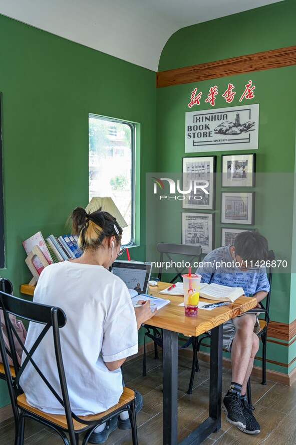 Students are reading in a green lacquered ''train book house'' in Yuping county, Guizhou province, China, on July 21, 2024. 