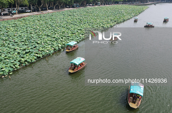 Tourists are taking a boat ride to see lotus flowers blooming on the West Lake in Hangzhou, China, on July 22, 2024. 