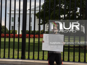 A visitor is holding a sign with the words ''Bye Joe'' in front of the White House in Washington, DC, USA, on July 21, 2024. The day Joe Bid...