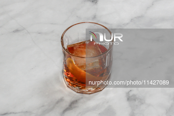 A cocktail ''Negroni'' is sitting on a bright background. 