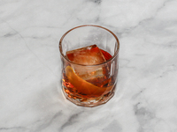 A cocktail ''Negroni'' is sitting on a bright background. (