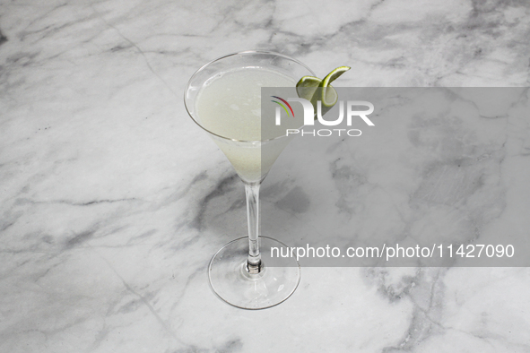 A cocktail ''Gimlet'' is sitting on a bright background. 