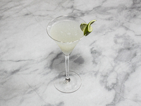 A cocktail ''Gimlet'' is sitting on a bright background. (