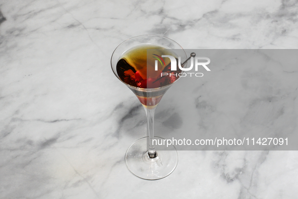 A cocktail ''Manhattan'' is sitting on a bright background. 