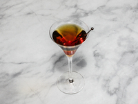 A cocktail ''Manhattan'' is sitting on a bright background. (