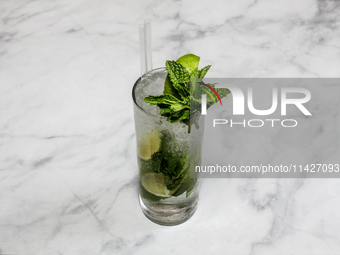 A cocktail ''Mojito'' is sitting on a bright background. (