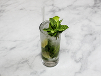 A cocktail ''Mojito'' is sitting on a bright background. (