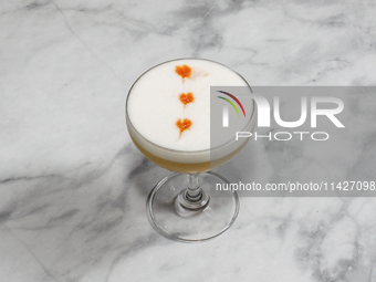 A cocktail ''Amaretto Sour'' is sitting on a bright background. (