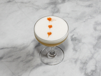 A cocktail ''Amaretto Sour'' is sitting on a bright background. (