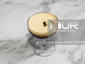 A cocktail ''Espresso Martini'' is sitting on a bright background. (