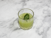 A cocktail ''Gin Basil Smash'' is sitting on a bright background. (