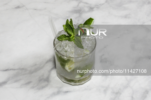 The cocktail ''Caipirinha'' is sitting on a bright background. 