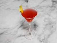 A cocktail ''Cosmopolitan'' is sitting on a bright background. (